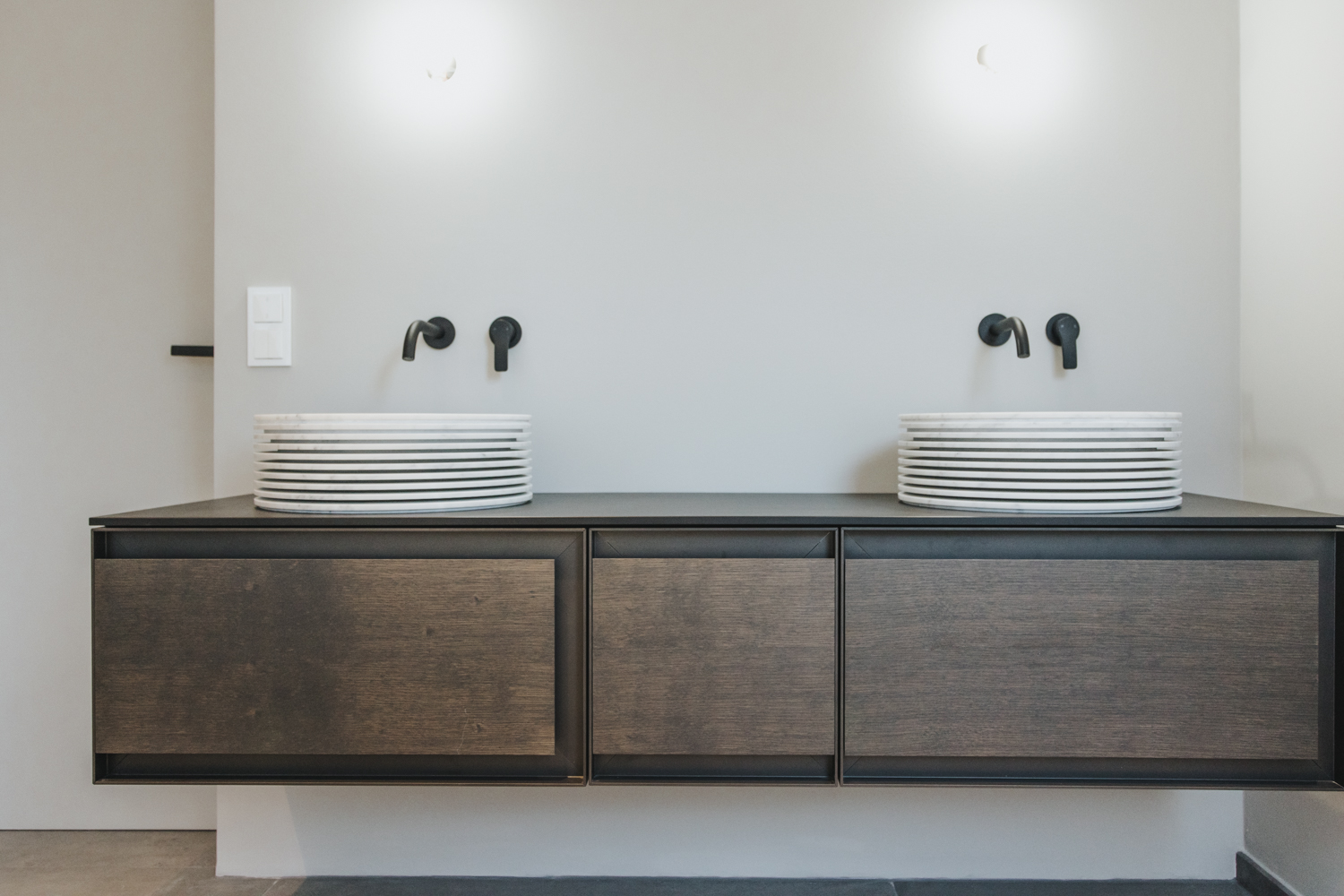 Designer bathroom fixtures and high-end faucets integrated into a minimalist layout.